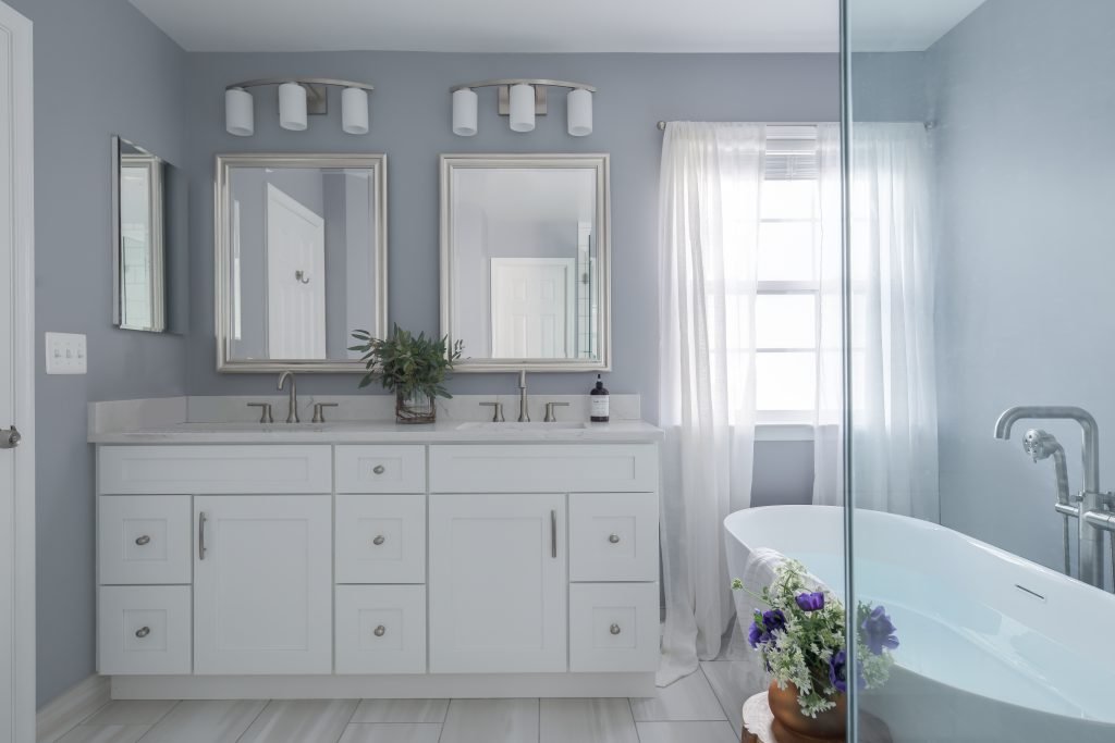 Modern Ballston bathroom remodeling design featuring a freestanding bathtub, double vanity, glass shower enclosure, and bright neutral finishes.