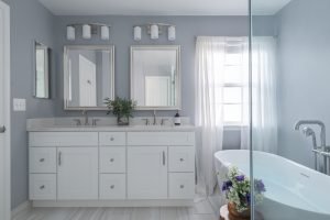 Modern Ballston bathroom remodeling design featuring a freestanding bathtub, double vanity, glass shower enclosure, and bright neutral finishes.
