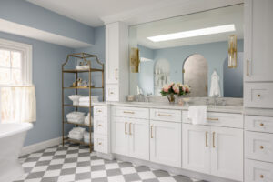 Bright bathroom remodel with a custom white vanity and gold fixtures